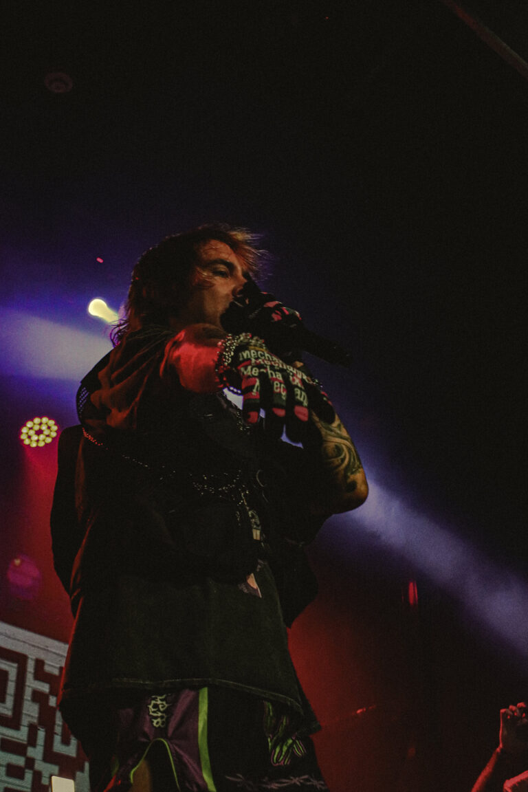 Rapper canta de olhos fechados com o QR code ao fundo — Sad Baile Joker, Halloween em São Paulo, 17/10/2026