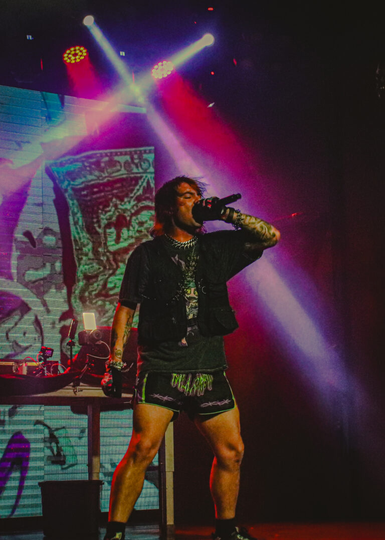 Rapper canta diante do telão com luzes cruzadas — Sad Baile Joker, Halloween em São Paulo, 17/10/2026