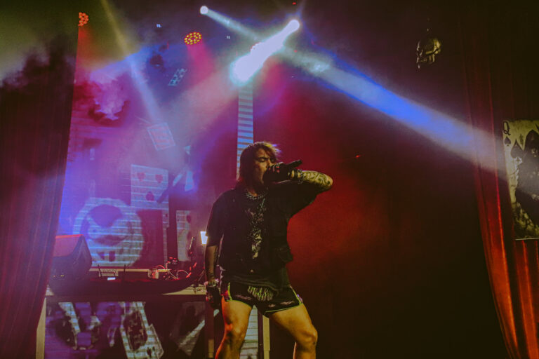 Palco aberto com o rapper e luzes coloridas cruzadas — Sad Baile Joker, Halloween em São Paulo, 17/10/2026