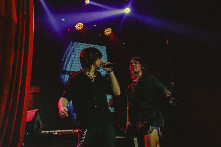 Dupla de artistas no palco sob luzes azuis e roxas — Sad Baile Joker, Halloween em São Paulo, 17/10/2026