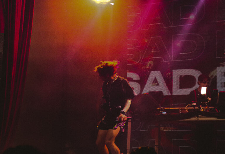 Artista no palco diante do letreiro Sad com luz alaranjada — Sad Baile Joker, Halloween em São Paulo, 17/10/2026