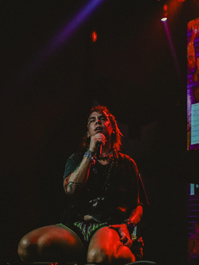 Rapper sentado na beira do palco cantando — Sad Baile Joker, Halloween em São Paulo, 17/10/2026
