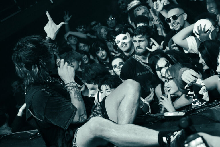 Rapper no meio do público em foto preto e branco — Sad Baile Joker, Halloween em São Paulo, 17/10/2026