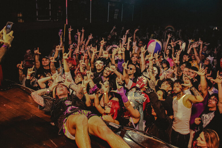 Público de mãos erguidas e artista deitado no palco — Sad Baile Joker, Halloween em São Paulo, 17/10/2026