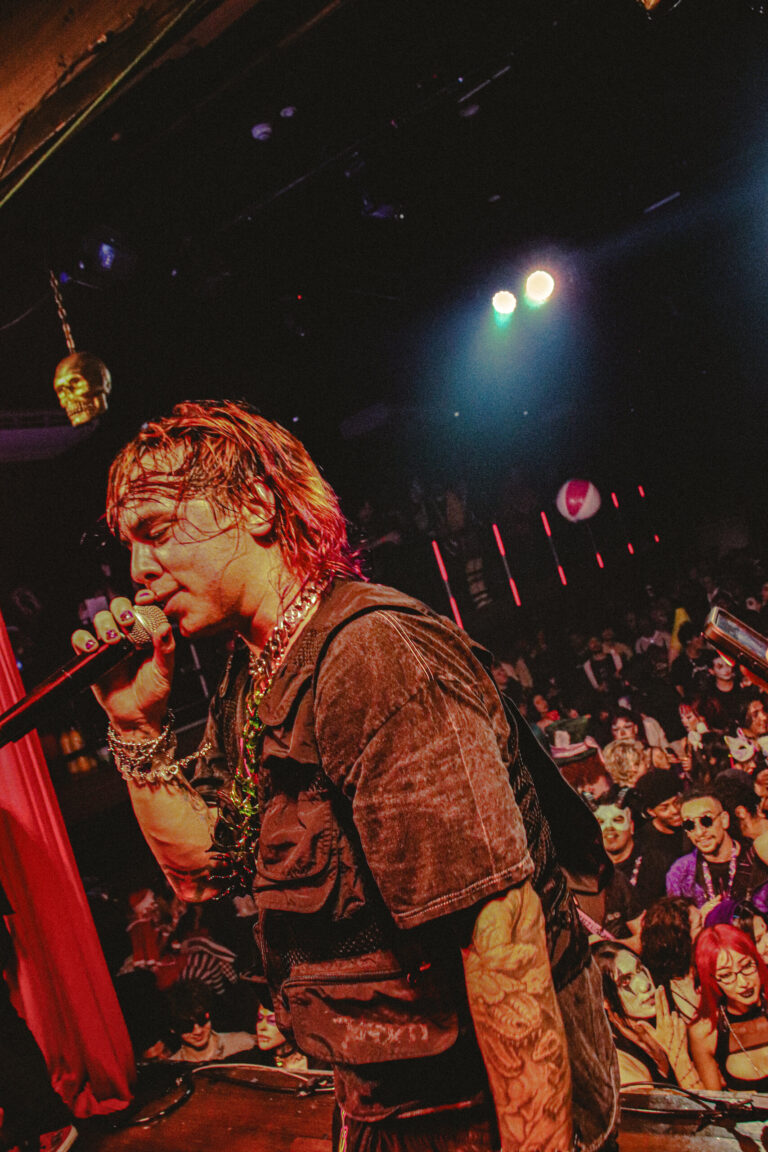 Rapper de cabelo descolorido canta na beira do palco — Sad Baile Joker, Halloween em São Paulo, 17/10/2026