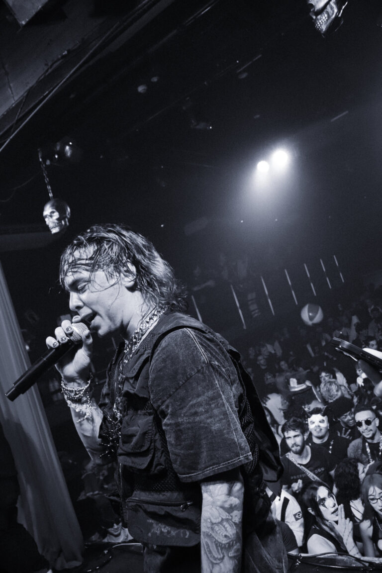 Rapper canta em preto e branco com a pista atrás — Sad Baile Joker, Halloween em São Paulo, 17/10/2026