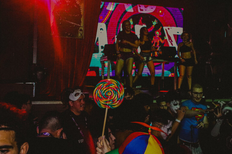 Palco com dançarinas e pirulito gigante na pista — Sad Baile Joker, Halloween em São Paulo, 17/10/2026