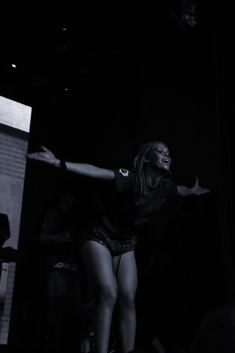 Dançarina de braços abertos em preto e branco — Sad Baile Joker, Halloween em São Paulo, 17/10/2026
