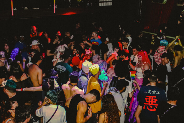 Pista cheia de fantasias coloridas vista de cima — Sad Baile Joker, Halloween em São Paulo, 17/10/2026