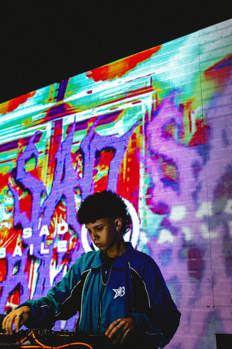 DJ sob o telão colorido com o letreiro da festa — Sad Baile Joker, Halloween em São Paulo, 17/10/2026