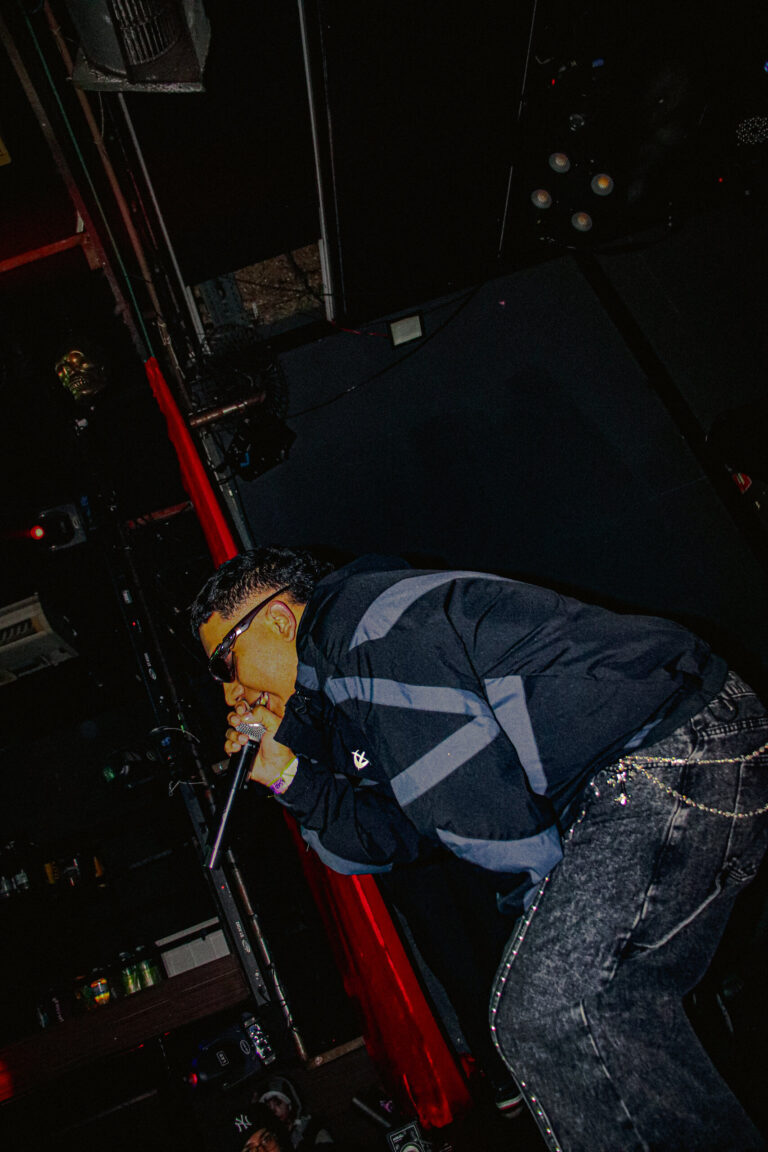 Rapper de óculos escuros e jaqueta jeans visto de cima — Sad Baile Joker, Halloween em São Paulo, 17/10/2026