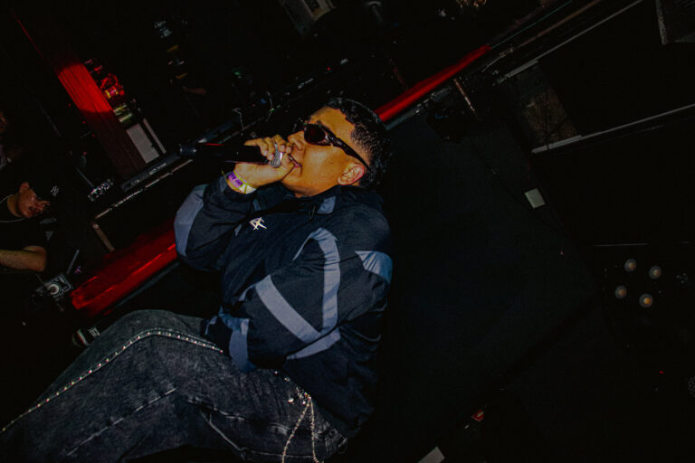 Rapper de óculos canta inclinado sobre o palco — Sad Baile Joker, Halloween em São Paulo, 17/10/2026