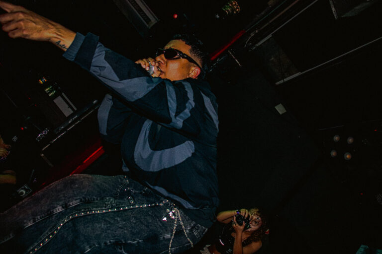 Rapper de óculos aponta para o alto — Sad Baile Joker, Halloween em São Paulo, 17/10/2026