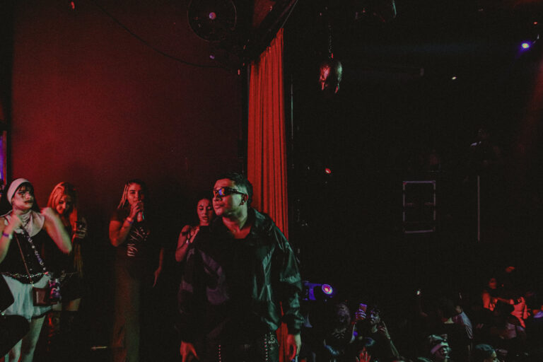 Grupo de artistas no palco sob luz vermelha — Sad Baile Joker, Halloween em São Paulo, 17/10/2026