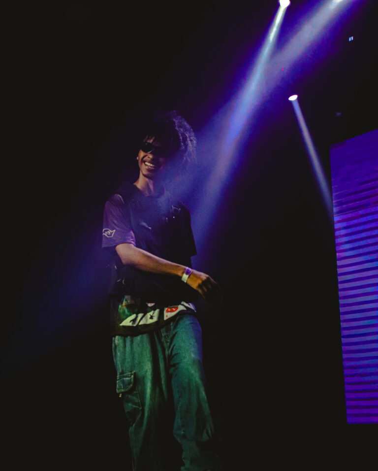 Rapper caminha no palco com luzes roxas ao fundo — Sad Baile Joker, Halloween em São Paulo, 17/10/2026