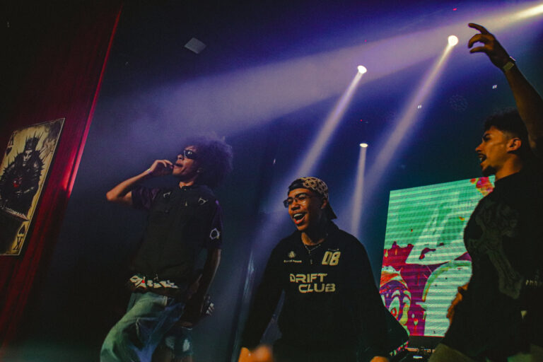 Trio de artistas no palco com luzes roxas — Sad Baile Joker, Halloween em São Paulo, 17/10/2026