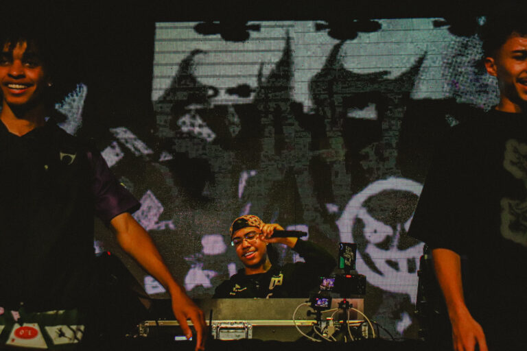 DJ na cabine com o telão de caveiras em preto e branco — Sad Baile Joker, Halloween em São Paulo, 17/10/2026