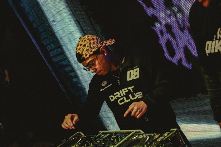 DJ de bandana estampada e camisa Drift Club mixando — Sad Baile Joker, Halloween em São Paulo, 17/10/2026