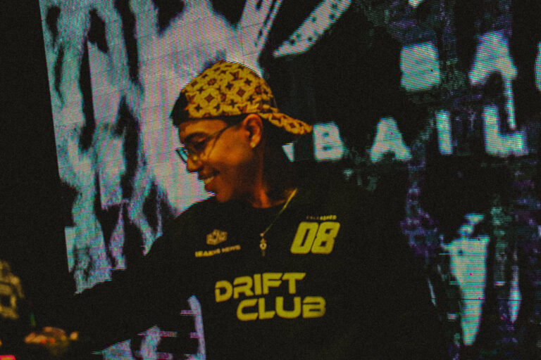DJ de bandana sorri diante do letreiro Sadbaile — Sad Baile Joker, Halloween em São Paulo, 17/10/2026