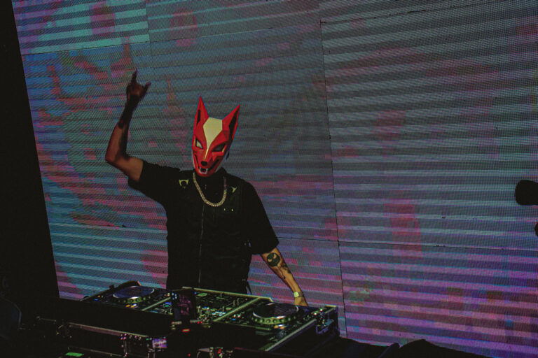 DJ de máscara de diabo ergue a mão — Sad Baile Joker, Halloween em São Paulo, 17/10/2026