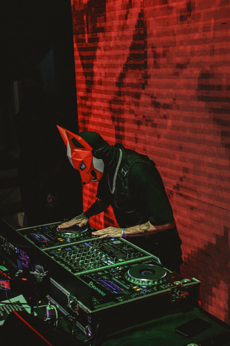 DJ de máscara vermelha na cabine sob luz vermelha — Sad Baile Joker, Halloween em São Paulo, 17/10/2026