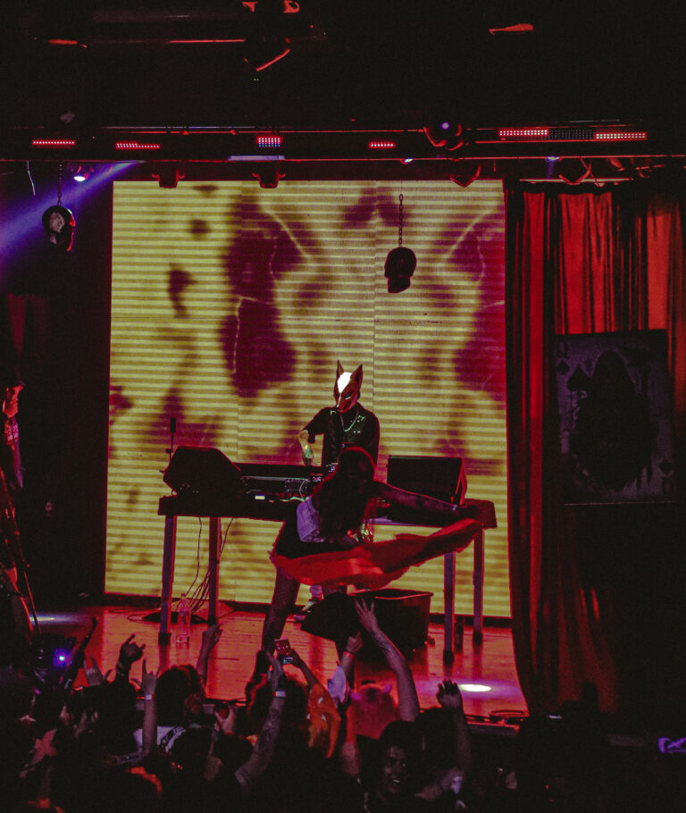 DJ na cabine diante do telão amarelo e vermelho — Sad Baile Joker, Halloween em São Paulo, 17/10/2026