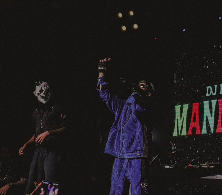 Mascarado e artista de agasalho azul no palco — Sad Baile Joker, Halloween em São Paulo, 17/10/2026