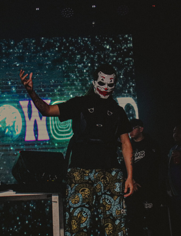 Artista com máscara de Coringa ergue a mão — Sad Baile Joker, Halloween em São Paulo, 17/10/2026