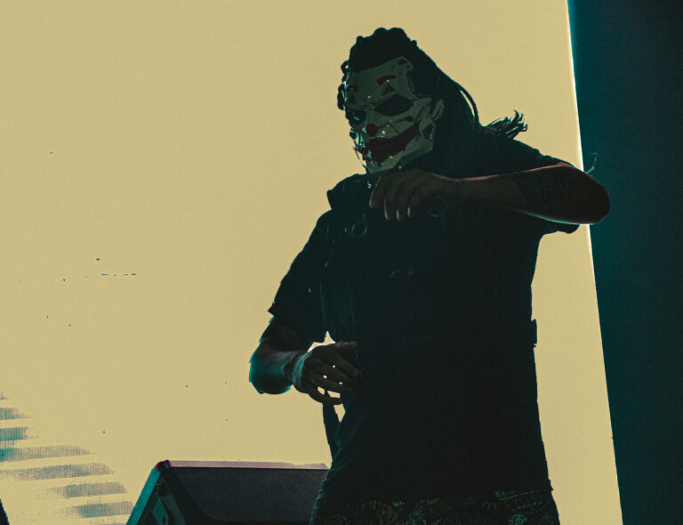 Silhueta de artista mascarado diante do telão claro — Sad Baile Joker, Halloween em São Paulo, 17/10/2026