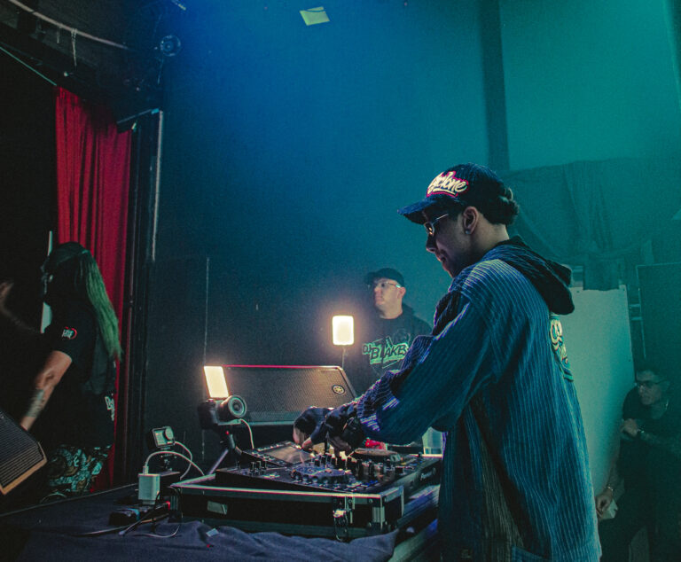 DJ de boné mixando com o palco iluminado em azul — Sad Baile Joker, Halloween em São Paulo, 17/10/2026