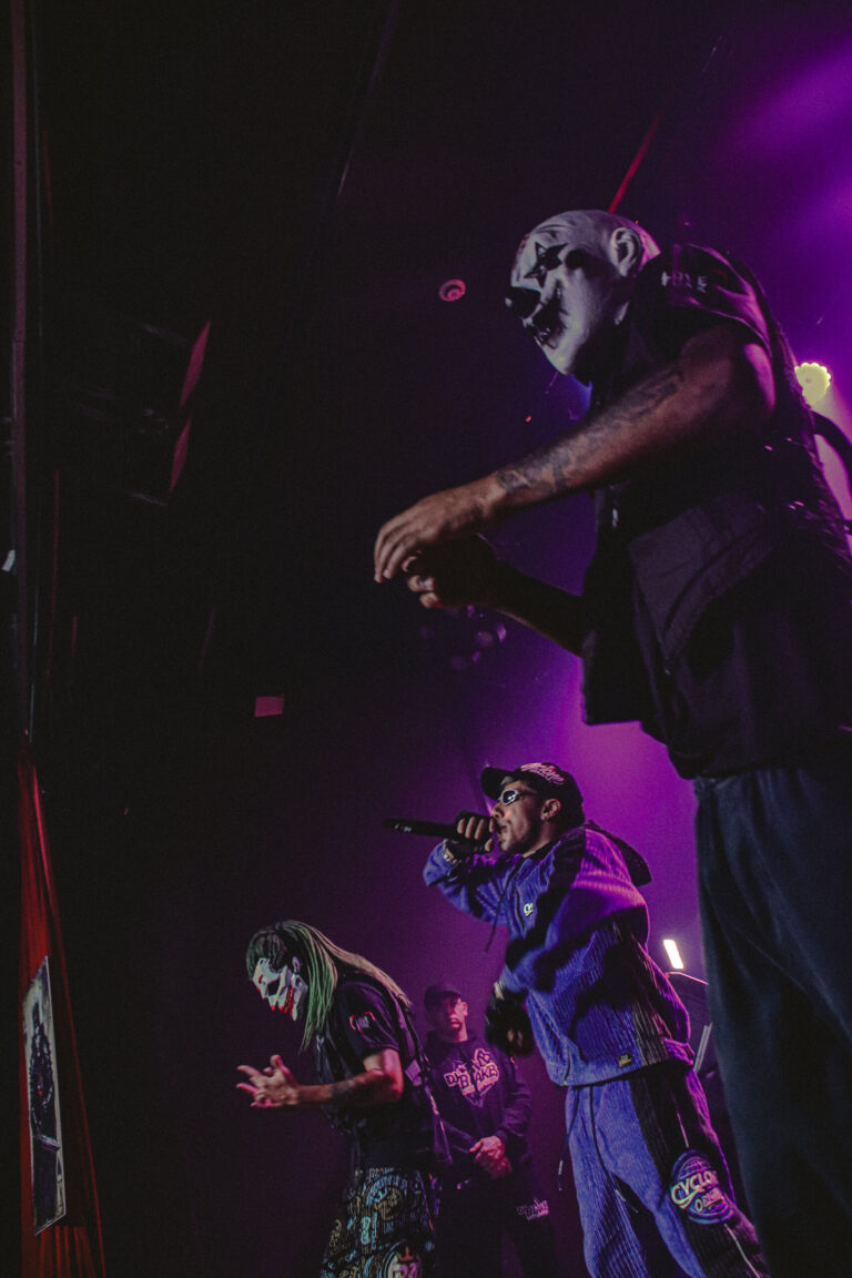 Artistas mascarados sob luz roxa — Sad Baile Joker, Halloween em São Paulo, 17/10/2026