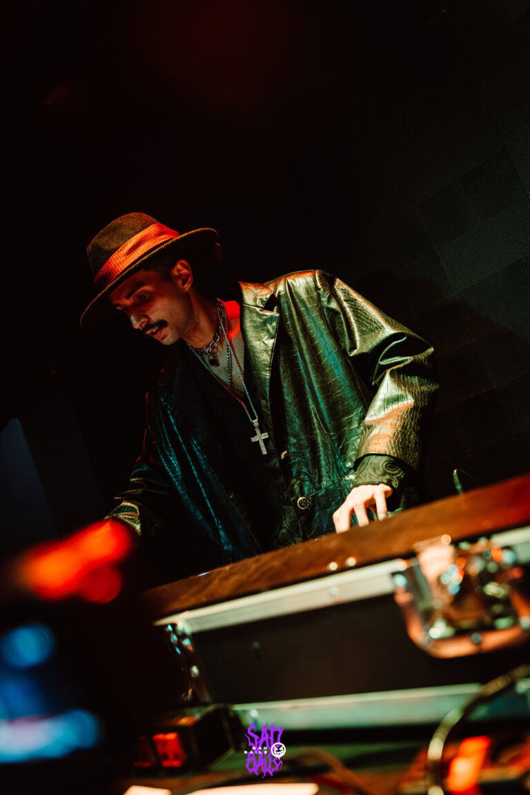 DJ de chapéu e jaqueta verde mixando — Sad Baile Joker, Halloween em São Paulo, 17/10/2026