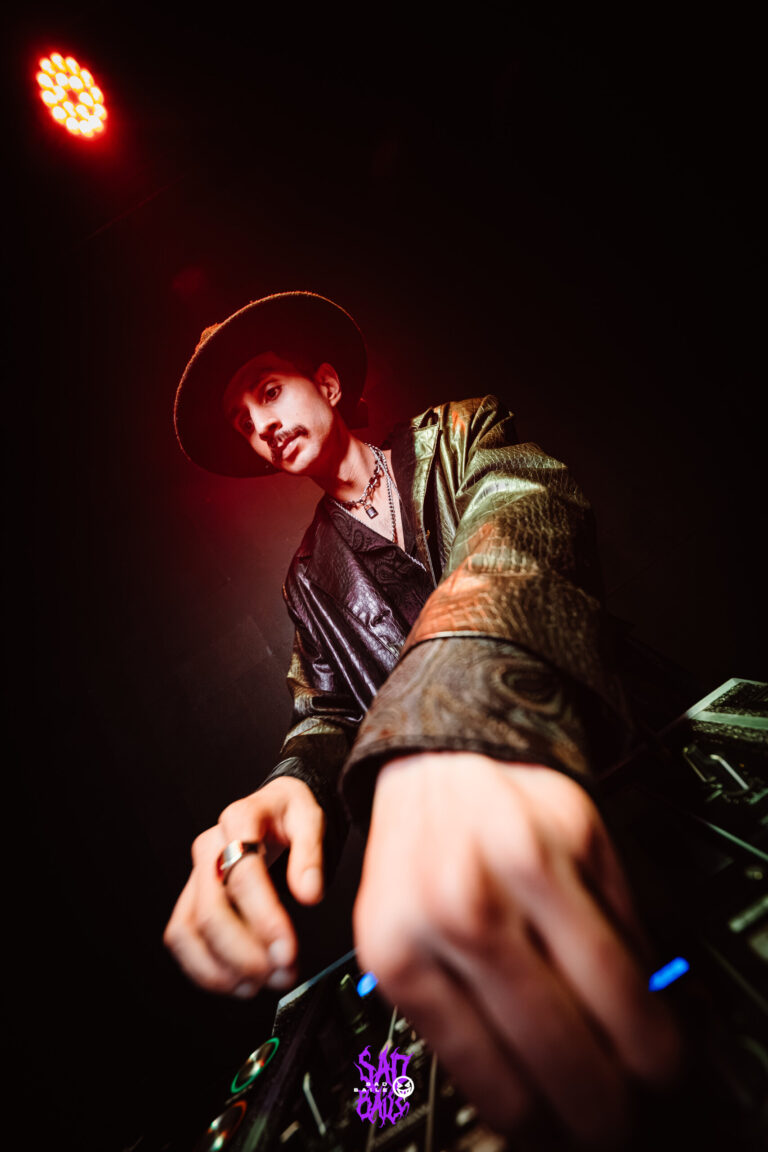 Mãos do DJ nos controles sob luz vermelha — Sad Baile Joker, Halloween em São Paulo, 17/10/2026