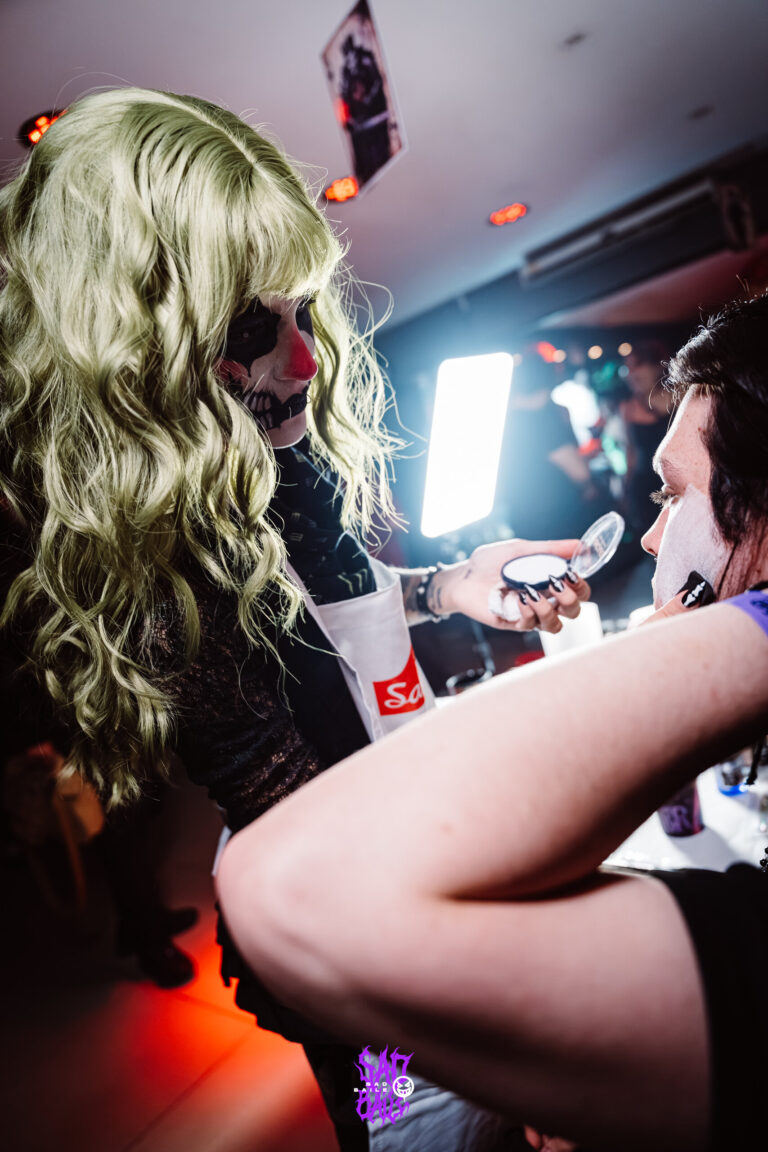 Participante recebe maquiagem no espaço de make — Sad Baile Joker, Halloween em São Paulo, 17/10/2026