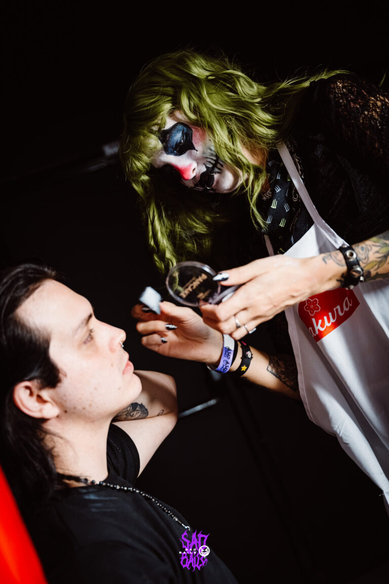 Maquiadora com maquiagem de caveira pinta um participante — Sad Baile Joker, Halloween em São Paulo, 17/10/2026
