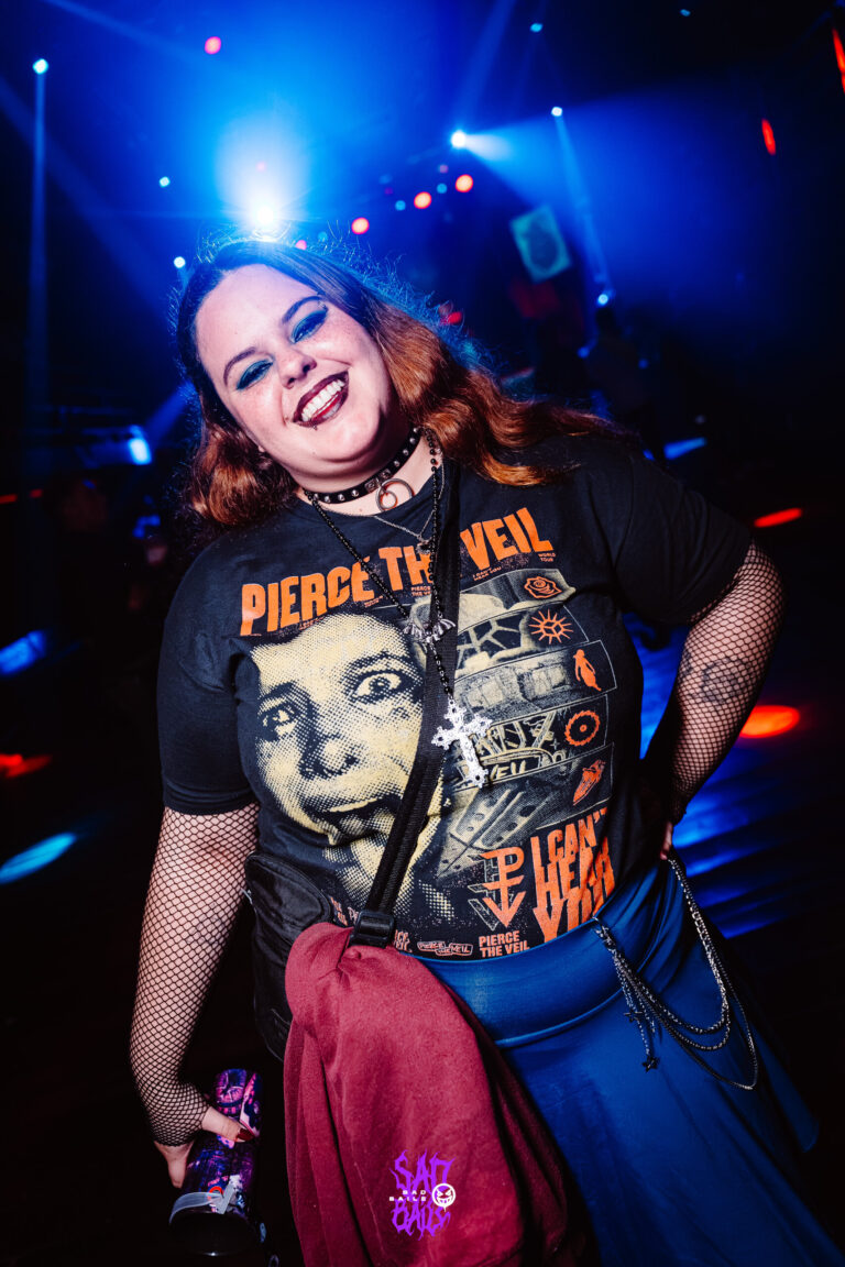Garota de camiseta de banda sorri na pista — Sad Baile Joker, Halloween em São Paulo, 17/10/2026