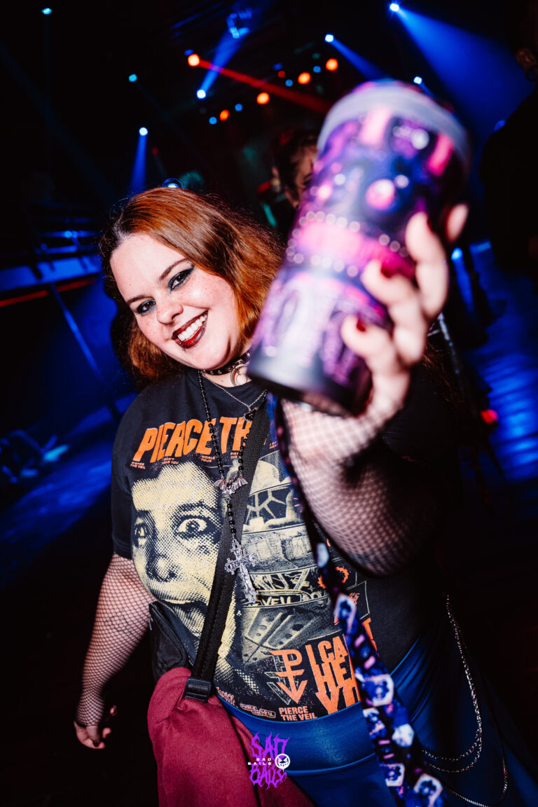 Garota de camiseta de banda ergue copo Joker — Sad Baile Joker, Halloween em São Paulo, 17/10/2026