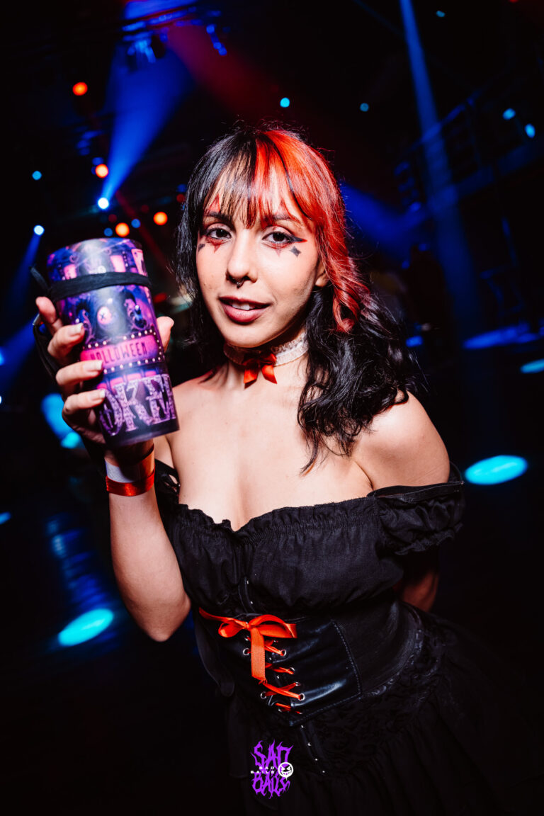 Garota de vestido preto e franja ruiva com copo Joker — Sad Baile Joker, Halloween em São Paulo, 17/10/2026