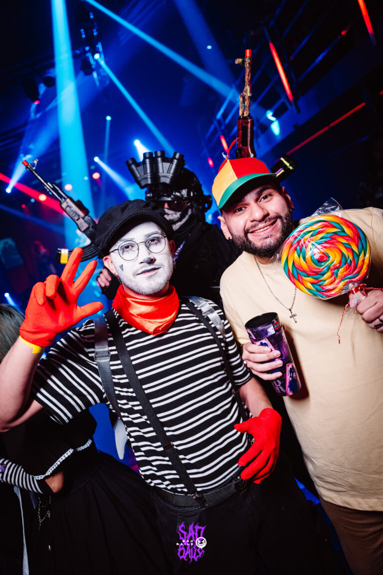 Mímico de luvas vermelhas e amigo com pirulito gigante — Sad Baile Joker, Halloween em São Paulo, 17/10/2026