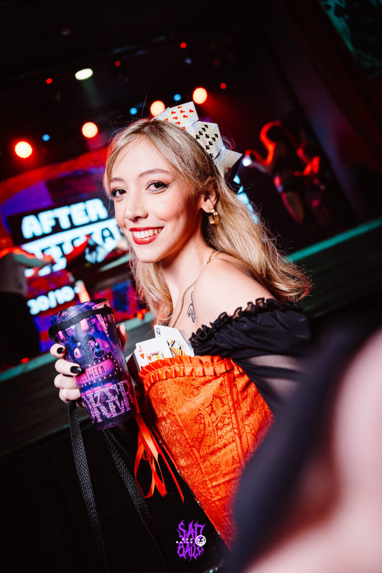 Rainha de corset vermelho sorri na pista — Sad Baile Joker, Halloween em São Paulo, 17/10/2026