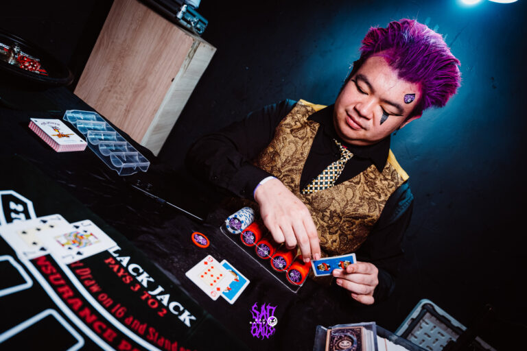 Crupiê distribui cartas na mesa de blackjack — Sad Baile Joker, Halloween em São Paulo, 17/10/2026