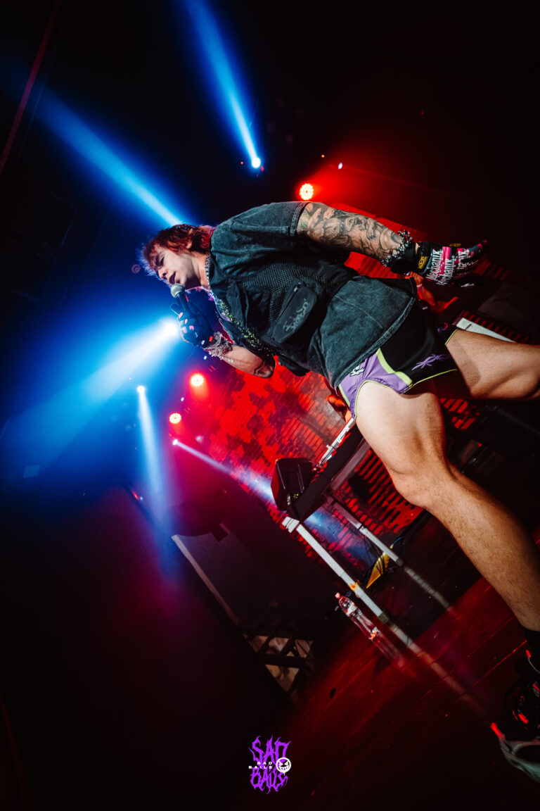 Artista pula no palco sob luzes azuis — Sad Baile Joker, Halloween em São Paulo, 17/10/2026