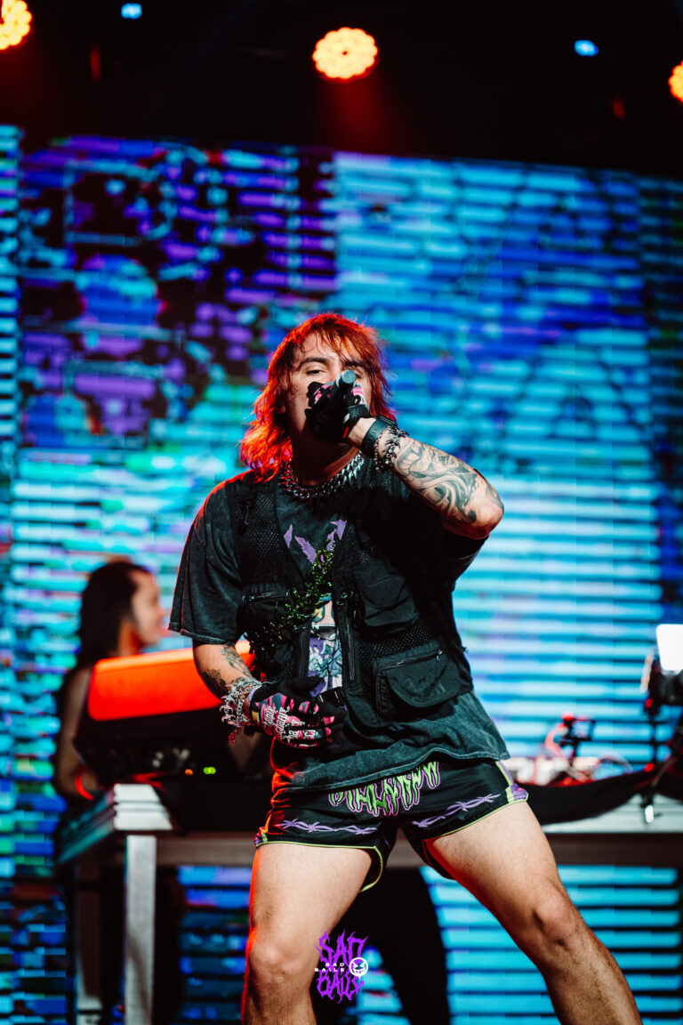 Artista de luvas pretas canta no palco — Sad Baile Joker, Halloween em São Paulo, 17/10/2026