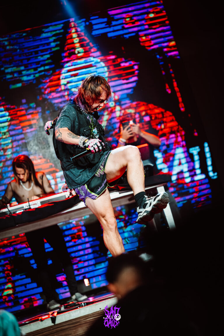 Artista sobe na mesa do palco com o DJ ao lado — Sad Baile Joker, Halloween em São Paulo, 17/10/2026