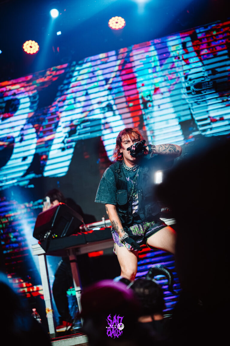 Artista no palco sob luzes azuis — Sad Baile Joker, Halloween em São Paulo, 17/10/2026