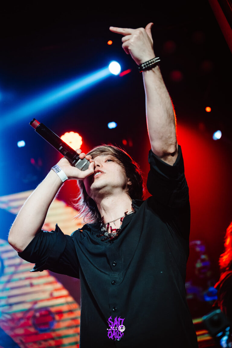 Cantor aponta para o alto no palco — Sad Baile Joker, Halloween em São Paulo, 17/10/2026