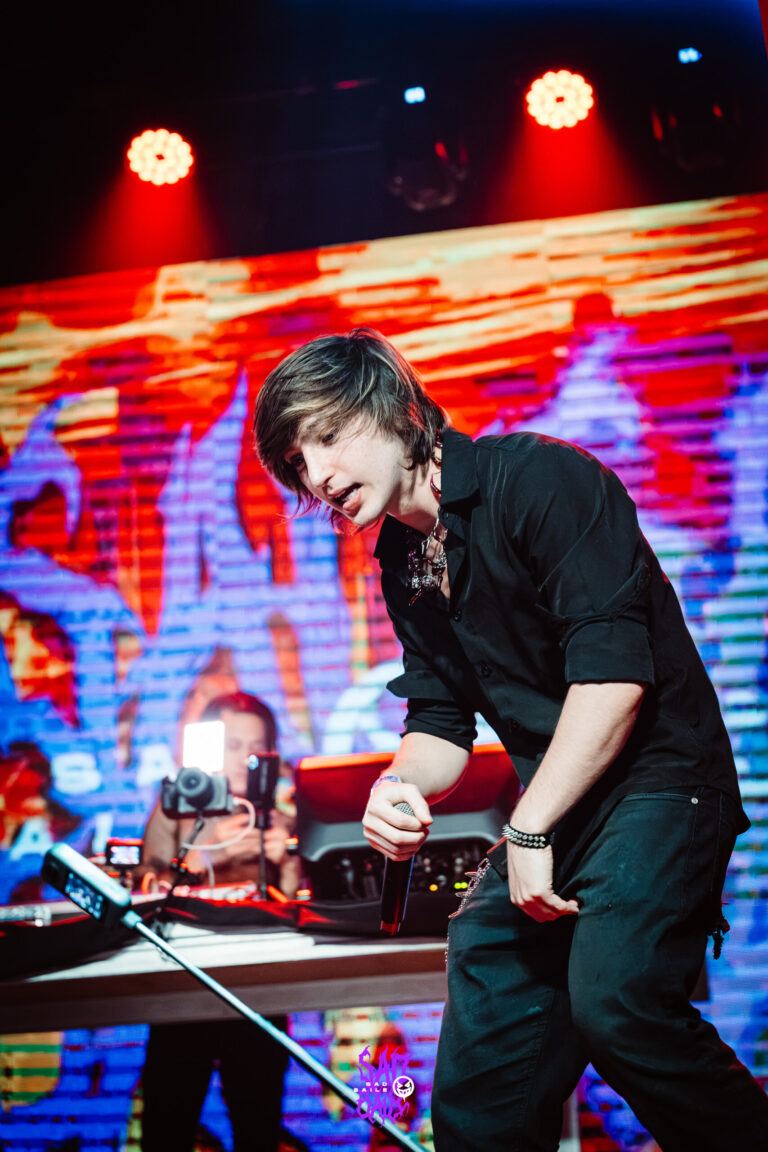 Cantor se inclina na mesa do DJ — Sad Baile Joker, Halloween em São Paulo, 17/10/2026