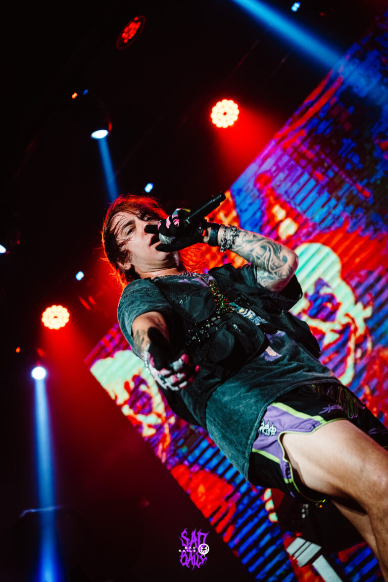 Artista de shorts lilás canta no palco — Sad Baile Joker, Halloween em São Paulo, 17/10/2026