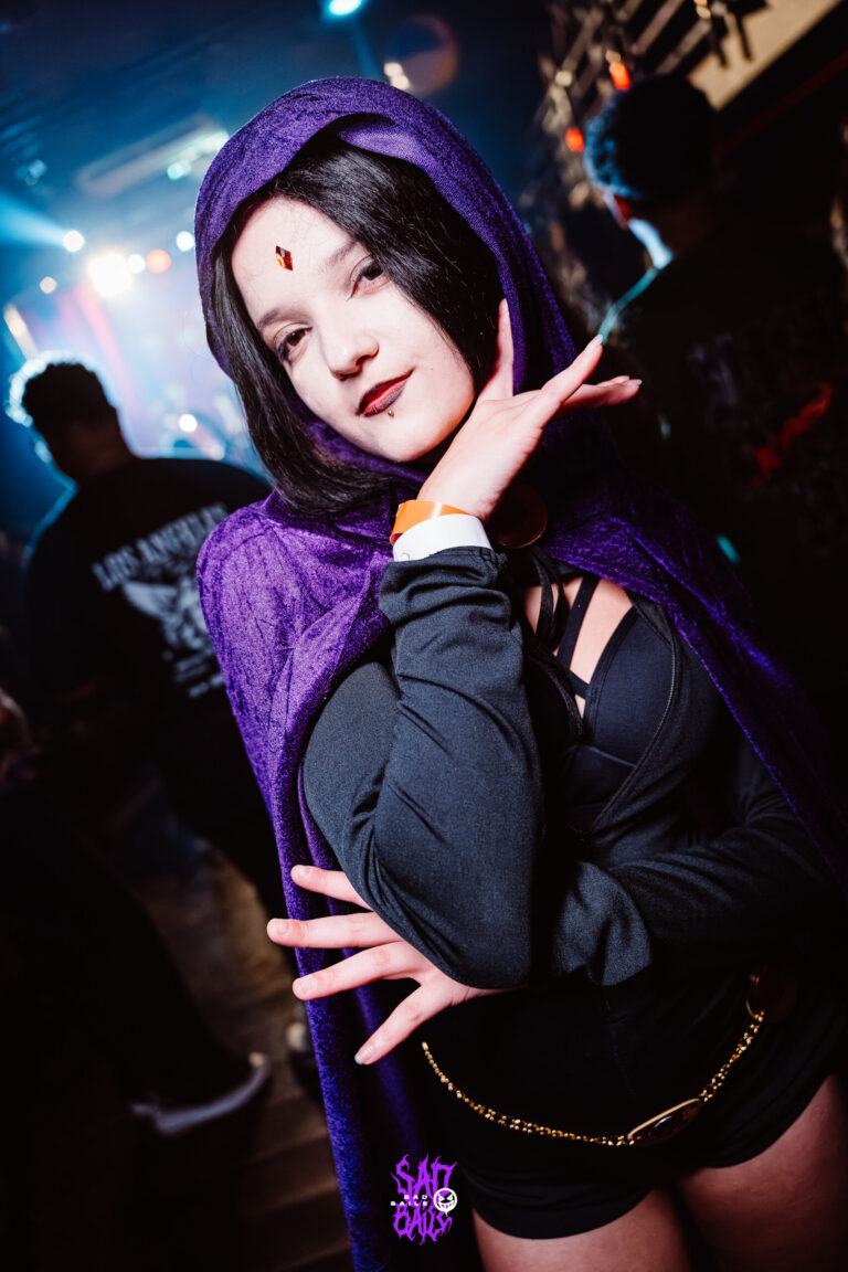 Fantasia de Ravena faz pose sob luz azul — Sad Baile Joker, Halloween em São Paulo, 17/10/2026