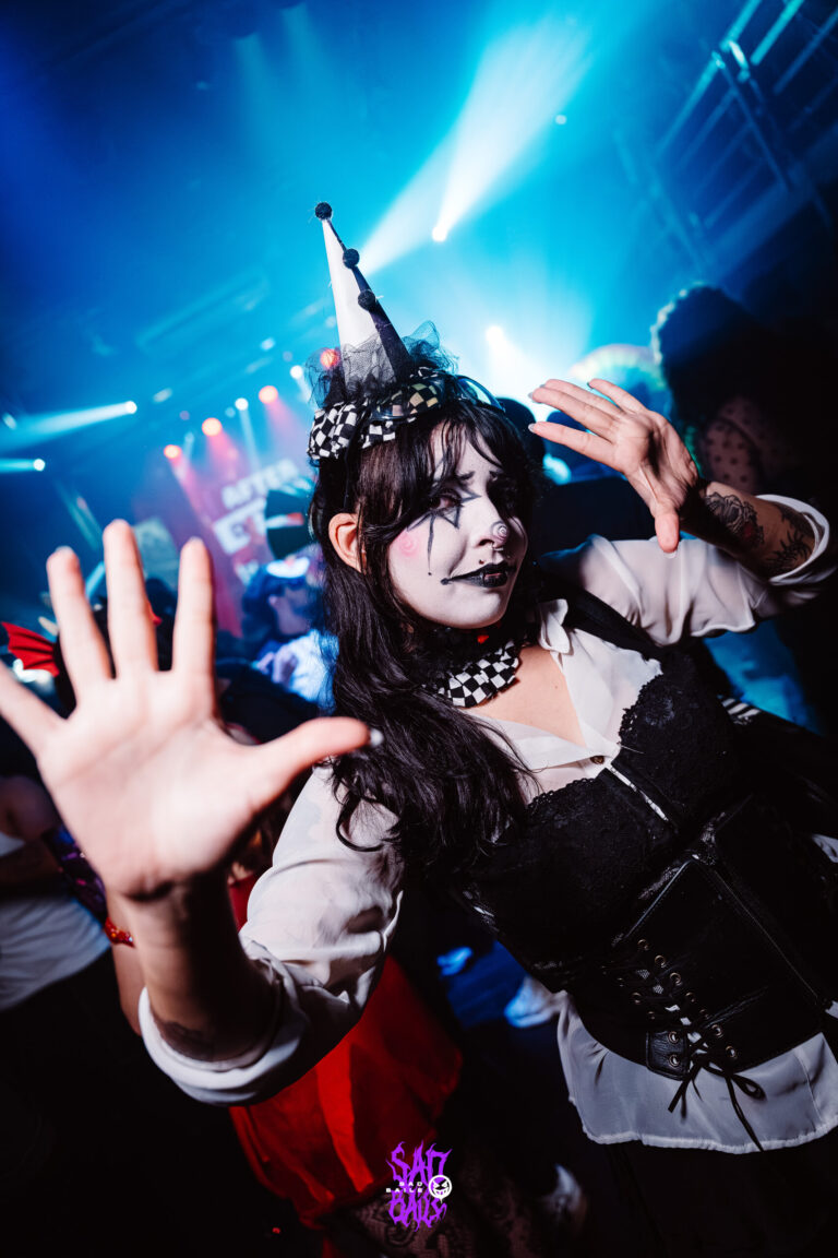 Palhaça de chapéu pontudo acena para a câmera — Sad Baile Joker, Halloween em São Paulo, 17/10/2026